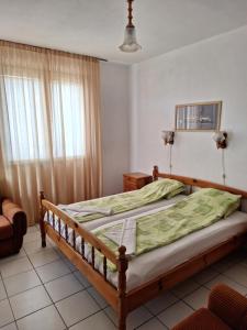 a bedroom with a bed with a green comforter at Topalovi Guest House in Chernomorets