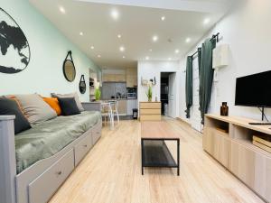 a living room with a couch and a tv at Gympie : joli studio cosy en centre-ville in Draguignan +7 photos
