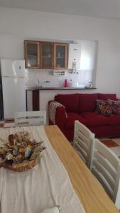 ein Wohnzimmer mit einem Tisch und einem roten Sofa in der Unterkunft Casa Isabella in Villa Dolores