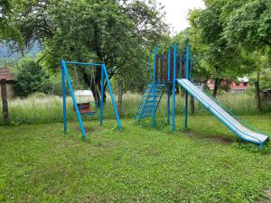un parque infantil con un tobogán azul en el césped en Guest House Lazar Raykov en Ribarica