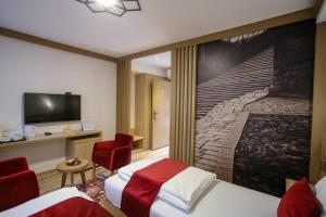 a hotel room with two beds and a flat screen tv at Hotel Emen in Mostar