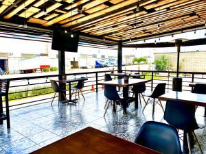 a restaurant with tables and chairs and a balcony at Hotel HAUS Ixtaczoquitlán in Orizaba