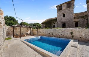 a swimming pool in front of a stone building at Amazing Home In Zlarin With Outdoor Swimming Pool in Zlarin