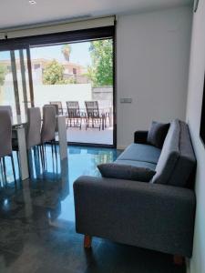 sala de estar con sofá, mesa y sillas en Experience Valencia Bnb - Luxury Apartment Naquera Chalet 298 con Piscina en Náquera