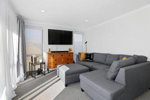 uma sala de estar com um sofá e uma televisão em Time Out on Towhai em Rotorua