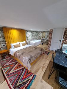 um quarto com uma cama grande e uma parede de tijolos em "Villa 70" Guesthouse em Gjirokastër