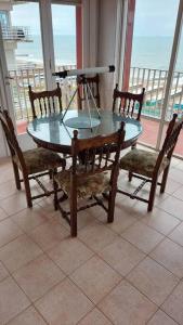 a glass table with two chairs and a camera at Peatonal al Mar in Miramar