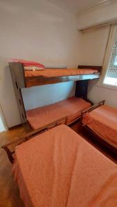 a room with two bunk beds and a window at Peatonal al Mar in Miramar +5 photos