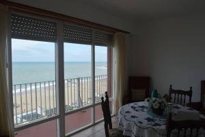 a bedroom with a view of the beach from a balcony at Peatonal al Mar in Miramar