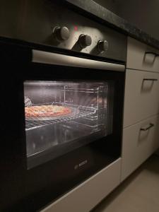 an oven with a pizza inside of it at Casa de Amor Sifa in As Sīfah