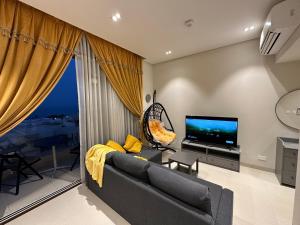 a living room with a couch and a tv at Casa de Amor Sifa in As Sīfah