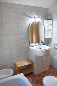 y baño con lavabo, aseo y espejo. en EL VALHALLA, TU LUGAR DE DESCANSO EN LA TIERRA., en Arenas de San Pedro