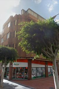 un grand bâtiment avec des arbres devant lui dans l'établissement 2 Bedrooms Flat + Balcony + Parking at Las Canteras Beach, à Las Palmas de Gran Canaria