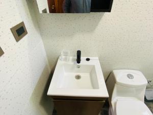 a bathroom with a white sink and a toilet at Cabañas EMC in Los Vilos