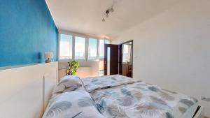 een slaapkamer met een bed en een blauwe muur bij Air conditioned, 2 room Apartment, New City in Koliba