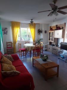 Una sala de estar con un sofá rojo y una mesa. en Résidence MADRID, en Alcossebre
