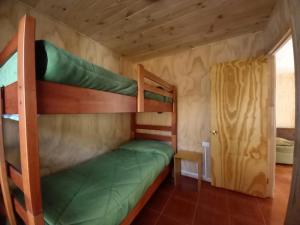 a bedroom with two bunk beds in a room at Cabañas Trinar del Chucao Lican Ray in Licán Ray