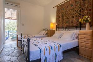 a bedroom with two beds and a large window at CalmNature in Agnontas