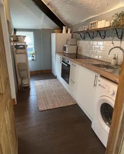 a kitchen with a sink and a washing machine at The Annexe in Winterbourne