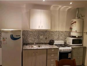 a kitchen with a white refrigerator and a sink at Departamento Centeno. Centrico. in Santa Rosa