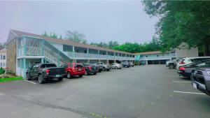 a parking lot with cars parked in front of a building at Hampton Motor Inn in Hampton