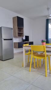 uma cozinha com uma mesa amarela e um frigorífico em Villa Roberta em Boca Chica