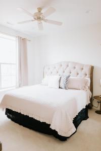 sypialnia z białym łóżkiem i wentylatorem sufitowym w obiekcie Inn On Central w mieście Le Mars