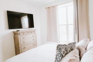 1 dormitorio con cama y vestidor con TV en Inn On Central en Le Mars