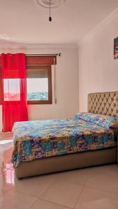 um quarto com uma cama num quarto com uma janela em Oued Laou Apartment em Oued Laou