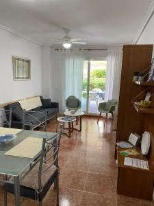 - un salon avec un canapé et une table dans l'établissement Apartamento con piscina en una preciosa playa, à Alcossebre
