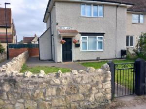 a stone fence in front of a house at Beautiful and Cosy 3 beds home for 6 guests near Doncaster Racecourse 