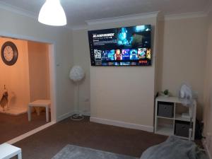a living room with a flat screen tv on a wall at Beautiful and Cosy 3 beds home for 6 guests near Doncaster Racecourse 