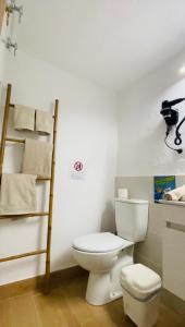 a bathroom with a toilet and a shelf with towels at Casa Gercko 2 in Yaiza