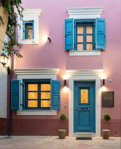 a pink building with blue windows and a door at Mosaic Luxury Home in Rhodes Town