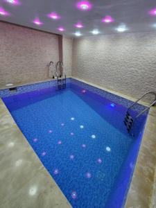 a large swimming pool in a room with purple lights at Résidence Miramare Marrakech in Marrakesh