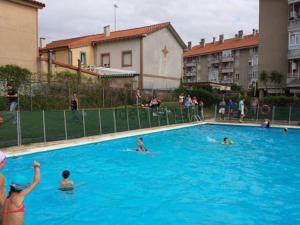 a group of people swimming in a swimming pool at Piso con Piscina in Santander