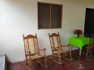 Mérida的住宿－Hostal La Cascada，一间设有两把椅子和一张桌子及一张绿桌的房间