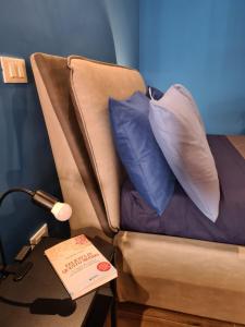 un sofá con almohadas y un libro sobre una mesa en Eco&Narciso apartment, en Monreale