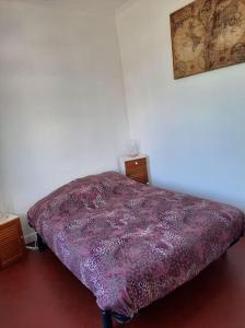Cama en habitación con manta morada en HAUT DE VILLA piscine 8 couchages, en La Ciotat