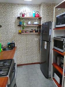 een keuken met een roestvrijstalen koelkast en een magnetron bij Loft Quilmes in Quilmes