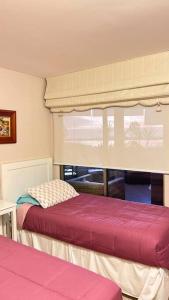 1 dormitorio con 2 camas y ventana en Departamento San Alfonso del Mar, primer piso, en Algarrobo