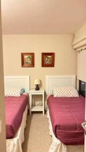 a bedroom with two beds and a side table at Departamento San Alfonso del Mar, primer piso in Algarrobo