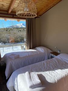 a bedroom with two beds and a window with mountains at Free Mountain in San Carlos de Bariloche