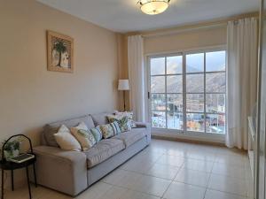 a living room with a couch and a large window at Las Teresitas Apartment in San Andrés