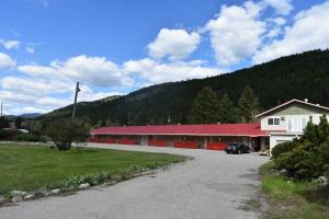 a red building with a car parked in front of it at Green View Motel and RV Park in Greenwood