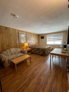 a living room with a couch and a bed and a table at Green View Motel and RV Park in Greenwood