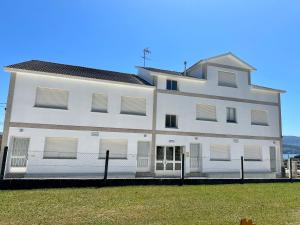 a white building with a fence in front of it at Naturmar in Raxó