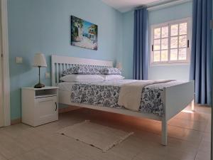a bedroom with a white bed and a window at Las Teresitas Apartment in San Andrés