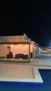 a building with a patio and a pool at night at Dunas Residence Casa n16 in Santo Amaro