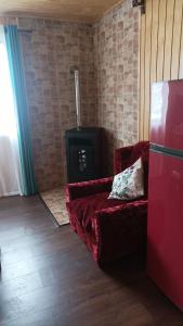 a living room with a red couch and a stove at Cabaña los pajaritos de frutillar in Frutillar